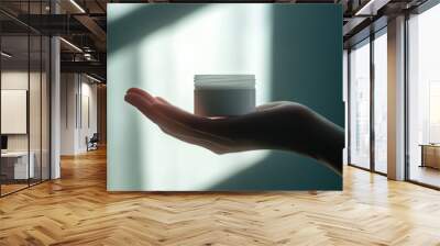 a hand holding white skin cream jar, close up, white background with shadow , ray of light Wall mural