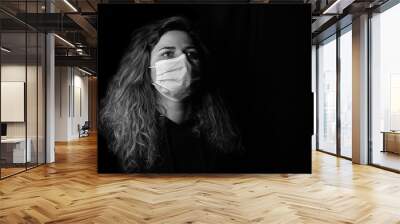 black and white art photography monochrome, girl with a medical mask on a black background, woman doctor, woman with intense look Wall mural