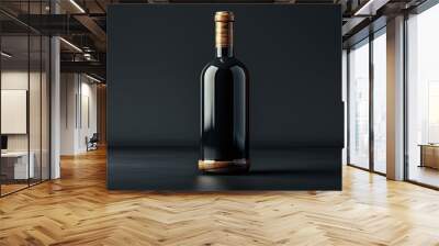 A single bottle of wine stands on a dark surface against a dark background. Wall mural