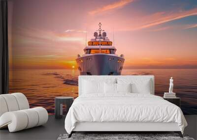 An impressive yacht navigating through the ocean captured from the front view against the backdrop of a stunning sunset, presenting a combination of luxury and tranquility. Wall mural