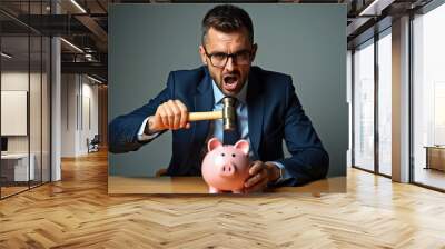 A businessman in a suit aggressively smashes a piggy bank with a hammer, symbolizing financial distress and economic challenges. Wall mural