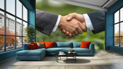 A business executive shaking hands in professional setting, symbolizing partnership and collaboration. green background adds touch of freshness and growth to moment Wall mural