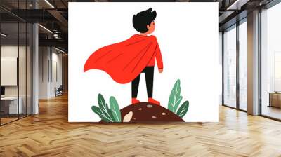 confident boy wearing red cape stands on mound, gazing into distance. vibrant colors and playful design evoke sense of adventure and imagination Wall mural