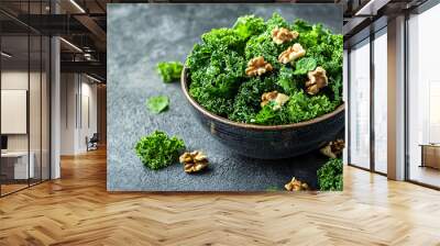 Fresh leafy green salad with kale and walnuts in bowl, showcasing vibrant colors and textures. Wall mural