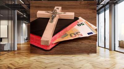 Crucifix on the background of the book with euro banknotes Wall mural