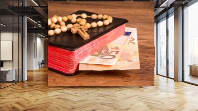 Rosary on the background of the book with euro banknotes Wall mural