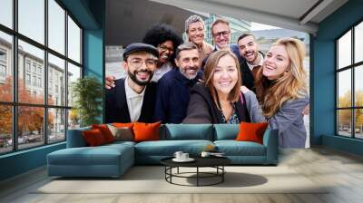 Cheerful group of multiracial business people taking a selfie together outside office building, looking at the camera smiling. Wall mural