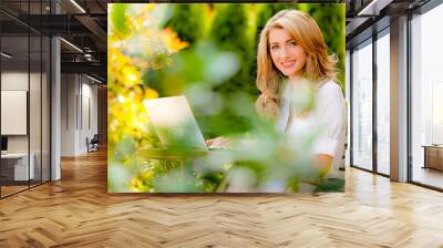 Frau mit Laptop im Garten Wall mural