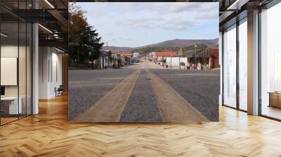 A street-level perspective view down a small town main street, Mena Street, Mena, Arkansas, with autumn colors on Rich Mountain in the background, small town America Wall mural