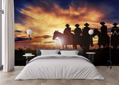 Group of cowboys on horseback at sunset Wall mural