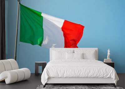 Italian national flag vawing in the wind with blue sky used as background Wall mural