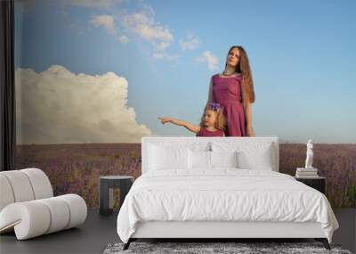 Little girl and mother at meadow of lavender. Wall mural