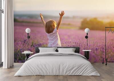 Little girl enjoy nature on meadow of lavender. Wall mural