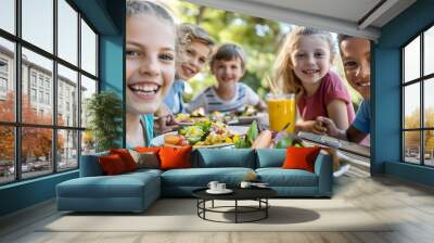 A group of smiling children enjoying a healthy picnic lunch together at a wooden table in a sunny outdoor setting. Ideal for themes of friendship, healthy eating, and outdoor activities. Wall mural