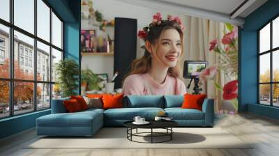 Smiling young woman wearing a flower crown while filming a vlog in a room decorated with plants and flowers. The scene is vibrant and reflects the trend of content creation and floral aesthetics. Wall mural