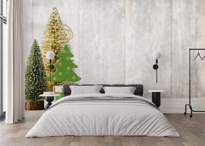 Artificial Christmas tree on a wooden background. Wall mural