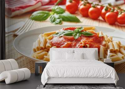 Pasta with tomato sauce and basil on white dish, vegetable in the background Wall mural