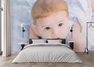 Cute baby boy lying on stomach and looking up Wall mural