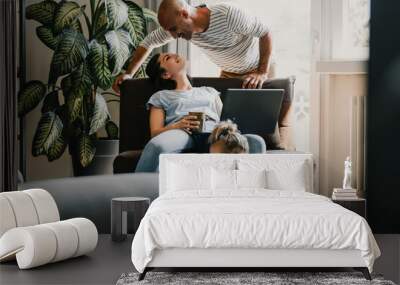 Happy family relaxing at home with technology Wall mural