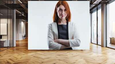 Young woman smirks, confidently crossing her arms Wall mural