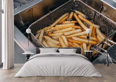 Close-up of french fries being fried in professional kitchen in a deep fryer Wall mural