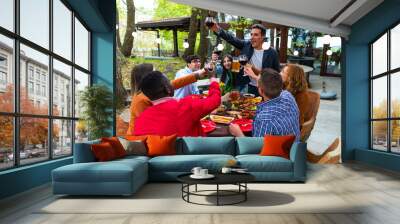 Young happy people having a barbecue dinner on a rooftop in patio - Group of friends having party and having fun – young people toasting in home terrace with beer glasses and wine glasses Wall mural