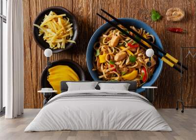 Fried chicken with mango and coconut milk with noodles. Prepared in a wok. Top view.  Served in a blue bowl. Wall mural