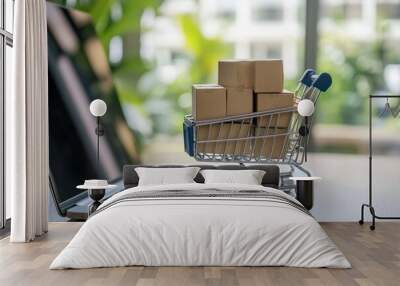 A miniature shopping cart with boxes inside stands on the table in front of an open laptop. Wall mural