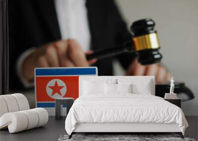 Judge's hand holding wooden gavel. Flag of North Korea. Sanctions in North Korea concept. Wall mural