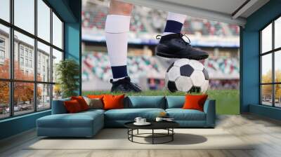 Legs of a female football player on soccer ball at stadium, close up Wall mural