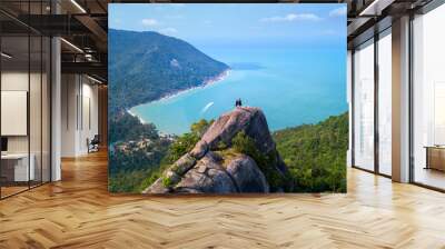 Man and woman standing on cliff's edge and looking into a sand beach of koh Phangan island,Thailand Wall mural