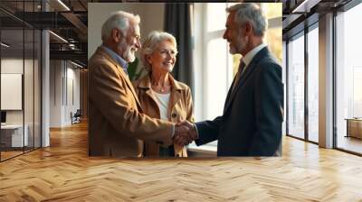 Elderly couple meeting with professional, warm interior lighting, window backdrop, business casual attire, handshake, friendly expressions, mature adults, office setting, natural pose, genuine interac Wall mural