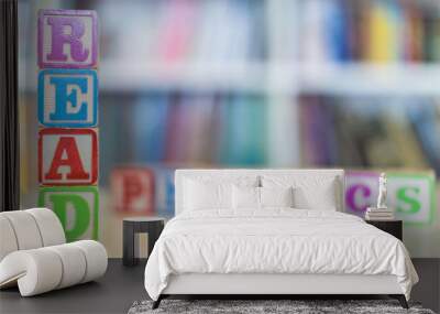 Alphabet blocks spelling the words read and phonics in front of a bookshelf Wall mural