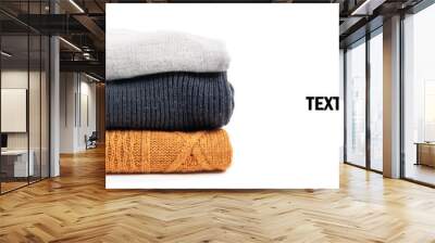 Sweaters in the stack on the white Wall mural