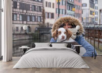 Young blue eyed woman carrying her dog Wall mural