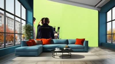 Behind the scenes of TV commercial movie film or video shooting production which crew team and photographer camera man setting up green screen for chroma key technique in big studio panorama view. Wall mural