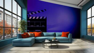 blurry images of movie slate or clapper board. hand holds empty film making clapperboard on color ba Wall mural