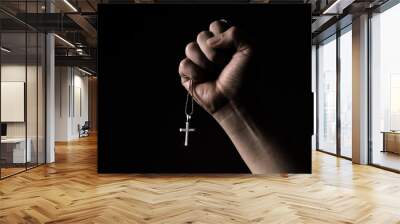 Silver crucifix or cross pendant and necklace on body or hand studio shot black color background which represent to praying for god or jesus for christian religion people who have faith Wall mural