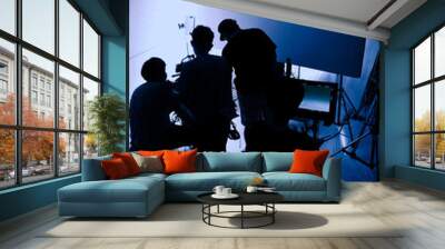 Video production behind the scenes. Making of TV commercial movie that film crew team lightman and cameraman working together with film director in studio. film production concept. Silhouette style. Wall mural