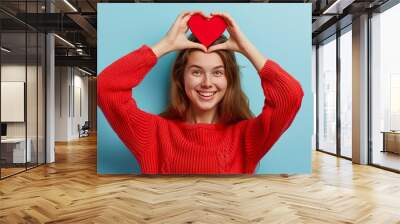 cheerful lovely woman with heart shape red love symbol in hand, person holding valentine day sign, romance and dating concept Wall mural