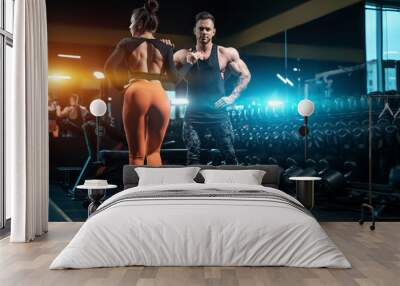 fitness couple of athletes or bodybuilders have workout and posing in modern gym Wall mural