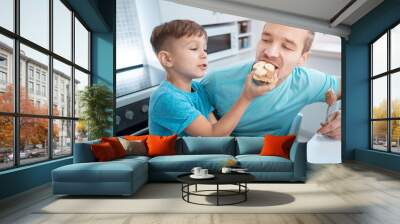 happy kid boy and father eating healthy peanut butter toast at home kitchen Wall mural