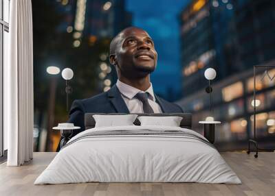 young african american businessman standing at city skyscrapers background and looking in future, entrepreneur planning business Wall mural