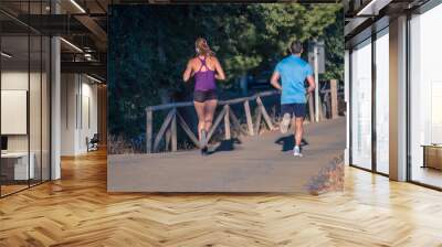 Young couple running in the park Wall mural