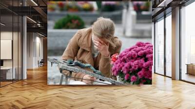 Young woman praying in a cemetery on All Saints' Day. Wall mural