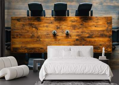 Overhead view of a long wooden conference table with black chairs and two plants. Wall mural