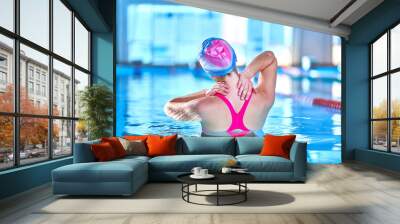 Fit active woman doing water gymnastics and aerobics in a sports swimming pool in leisure center. Pool workout, treatment and prevention of back and neck disease, healthy back Wall mural