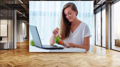 Healthy snack at office workplace. Happy business woman eating meals from lunch box at working table during lunch time. Container food at work Wall mural