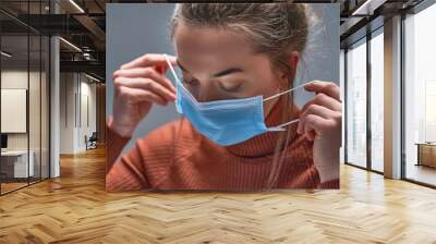 healthy woman putting on medical protective mask to health protection and prevention during flu viru Wall mural