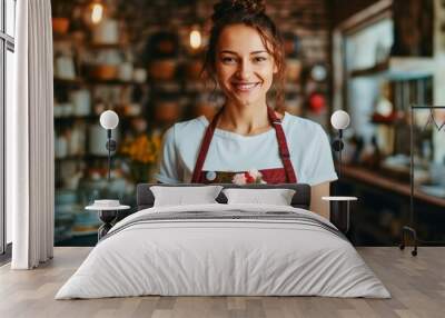 Portrait of cheerful young attractive satisfied smiling pastry chef woman wearing apron and holding plate with cake working in pastry shop Wall mural